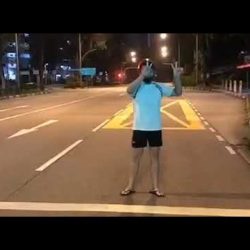Teenage boy making tik-tok dance video in the middle of the road