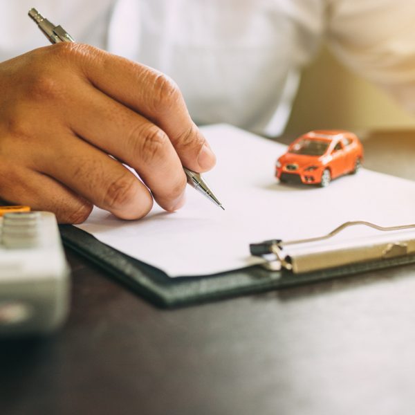Businessman with car insurance contract and calculator.
